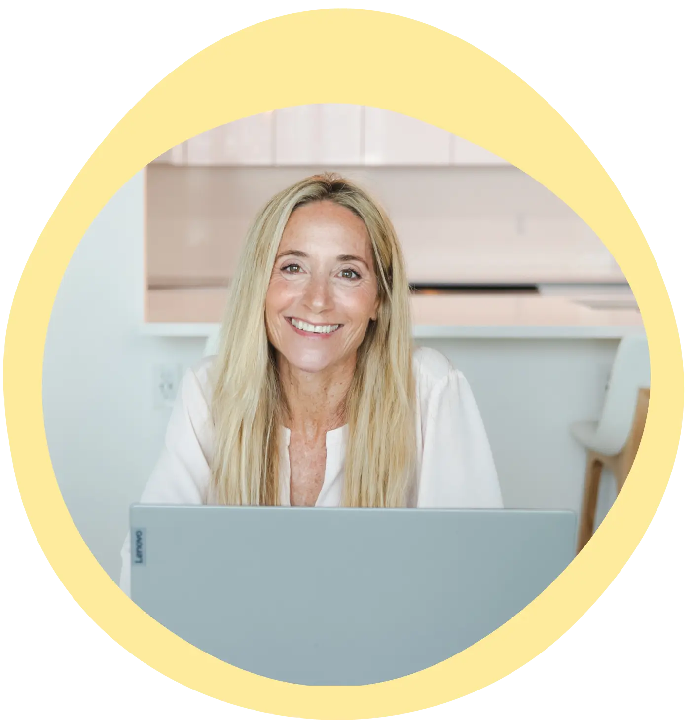 Leslie Crisco sitting at dining table on computer smiling.